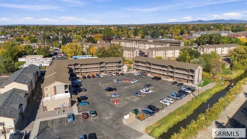 Aerial marketing photograph of commercial buildings and parking beside the river